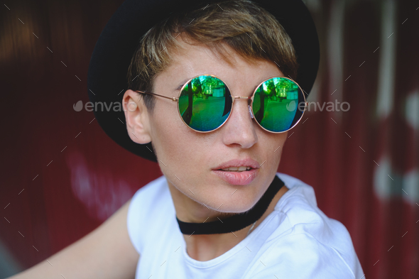Young woman portrait wearing stylish hat and round glasses - Stock Photo - Images