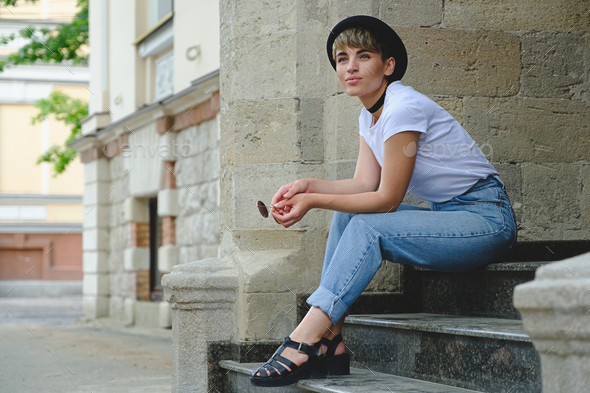 Beautiful young hipster woman posing sitting on stairs - Stock Photo - Images