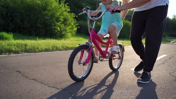 Little Girl Learning Ride Bicycle with Father alt