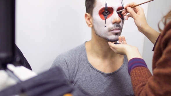 Make-up Artist Makes Greasepaint on Man's Face Before His Performance on Scene alt