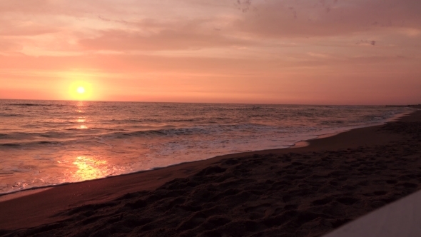 Setting Sun Leaves a Glare Path on the Water Reaching the Shore alt