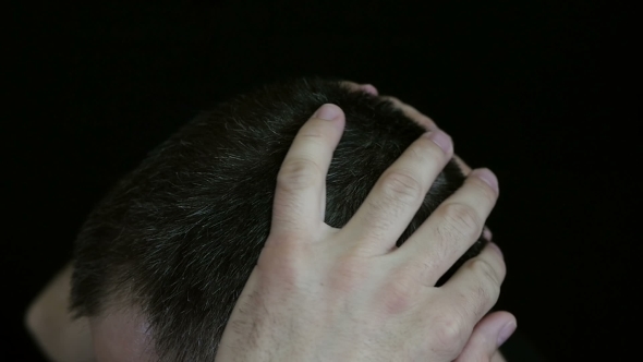 A Man Touches His Hair on His Head, Against a Black Background - 3. The Hair of a Man Is Gray.