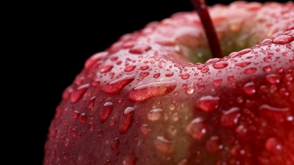 Beautiful Red Apple with Water Drops Rotates on Black Background alt