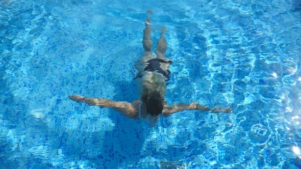 Woman Swim Under the Water and Emerges on the Surface. Young Beautiful Girl Swimming in Pool. Summer alt