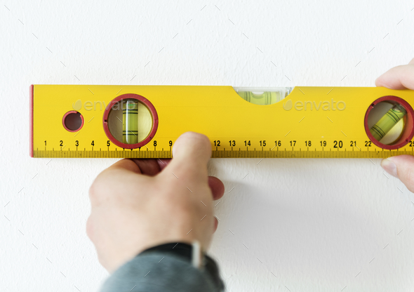 Man using water level meter measuring the wall - Stock Photo - Images