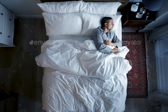 French man sleeping alone on bed - Stock Photo - Images