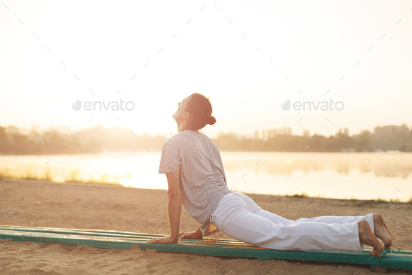 Young athletic men doing yoga on the sand in the park - Stock Photo - Images