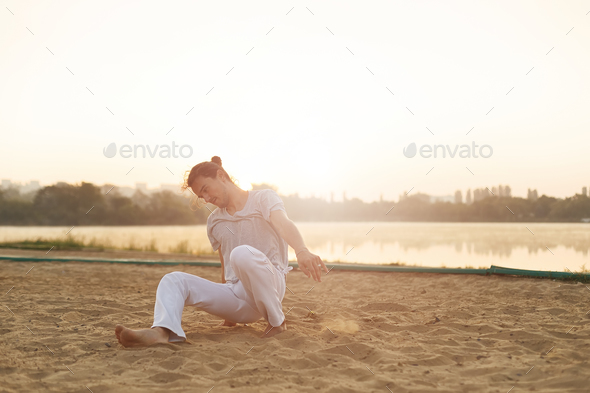 Athletic capoeira performer making movements on the beach - Stock Photo - Images
