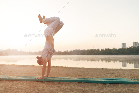 Athletic capoeira performer workout training on the beach sunris - Stock Photo - Images