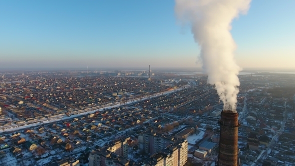Aerial Shot of Colossal Heating Chimney with Dense Smoke in Snowy City in Winter