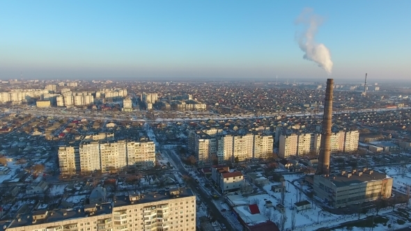 Aerial Shot of Huge Heating Chimney with Dense Smoke in Snowy City in Winter