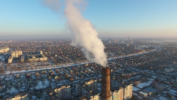 Aerial Shot of High Heating Tube with Dense Smoke in City in Snowy Winter