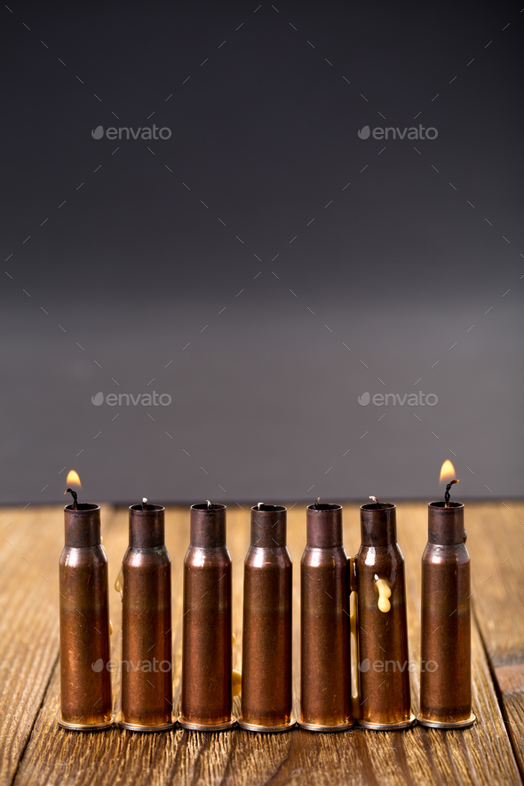 Burning candles and empty rifle cartridges. - Stock Photo - Images