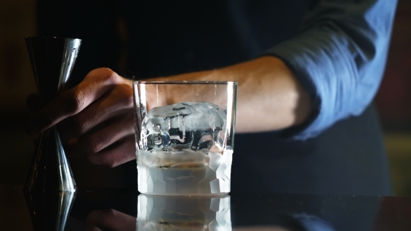 Professional Bartender Preparing a Cocktail with Ice a Mix of Alcohol in a Nightclub or Pub