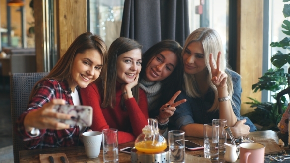 Four Beautiful Young Woman Doing Selfie in a Cafe, Best Friends Girls Together Having Fun