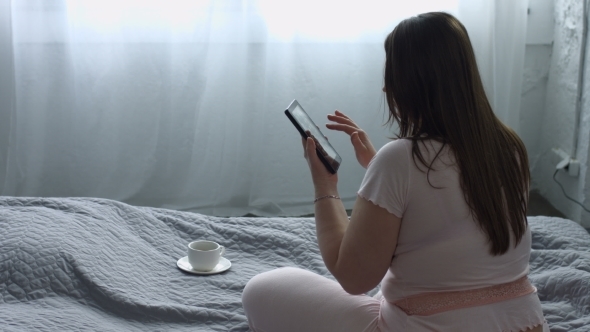 Relaxed Woman Networking with Tablet Pc on Bed alt