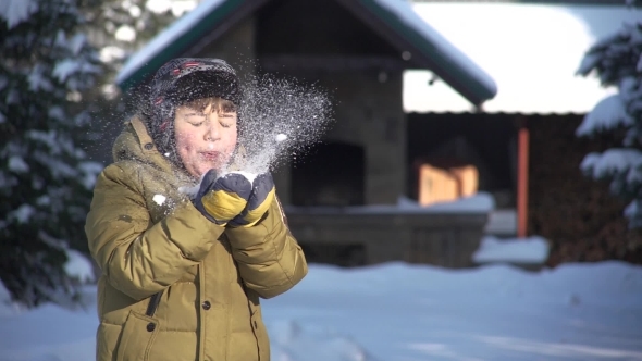 Child Blows on the Snow and Smiles