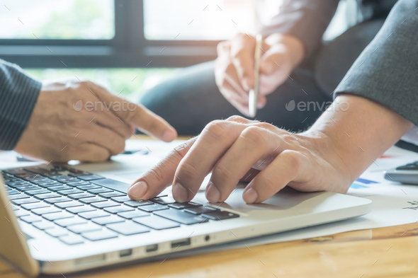 Business concepts,Two men use laptop analyze job,Pen in men\'s hand. Stock Photo by sarawutnirothon