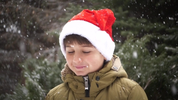 a Boy in a Red Christmas Hat Rejoices in Winter and Snow