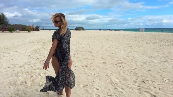 An Attractive Girl Walks Along the Beach and Flirts with the Camera