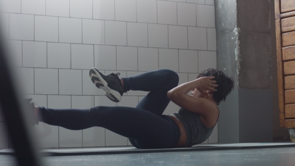 Side View Dolly Video of Black Woman Makes an Abs Routin on the Floor i Synny Loft alt