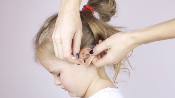 Woman Cleaning Her Daughter's Ear with a Cotton Swabs