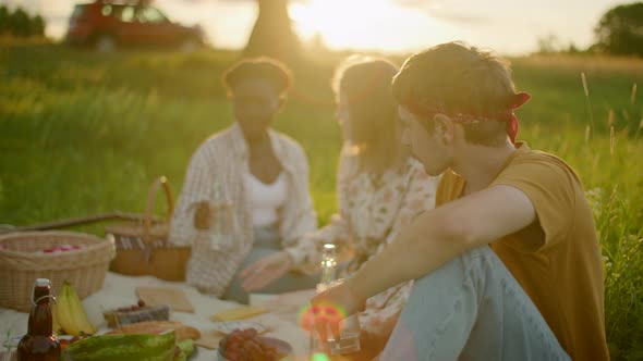 Five Diverse Multiethnic Young Friends Have a Picnic Eat Drink Smile Talk