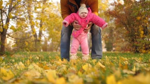 baby-with-his-father-walk-with-their-feet-on-autumn-leaves-by-zoteva