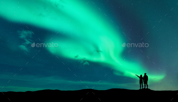 Aurora borealis and silhouette of man and woman Stock Photo by den-belitsky