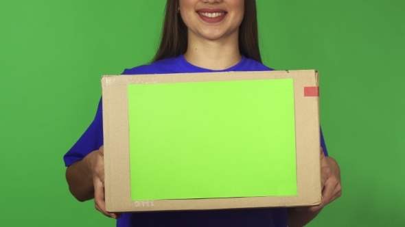 Cropped Shot of a Delivery Woman Smiling Holding Carboard Box with Copyspace alt
