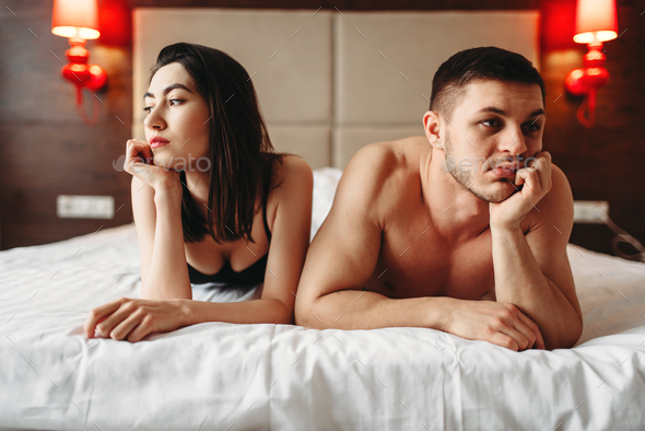 Love couple lies in bed, no sexual desire - Stock Photo - Images