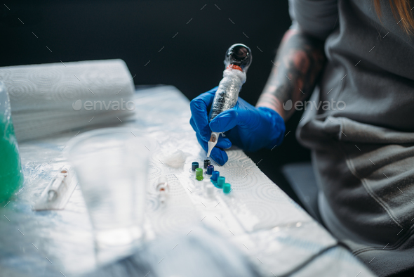 Female tattooist hands holds tattoo machine - Stock Photo - Images
