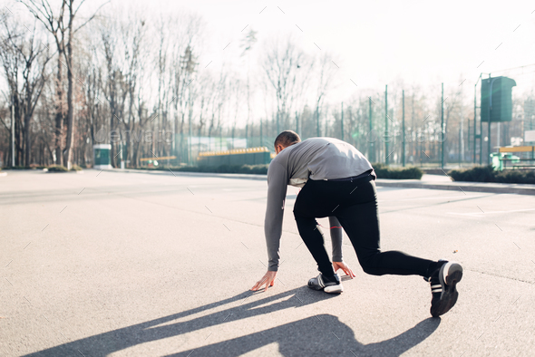 Male athlete prepares to run in autumn park - Stock Photo - Images