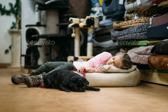 Little girl with puppy are sleep in pet shop - Stock Photo - Images