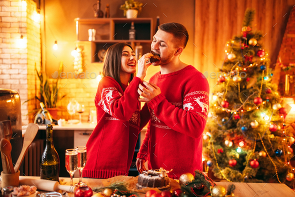 Wife is feeding her husband a christmas cake - Stock Photo - Images