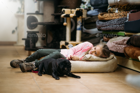 Little girl with puppy are sleep in pet shop - Stock Photo - Images