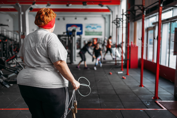 Fat sweaty woman, fit training with rope in gym - Stock Photo - Images