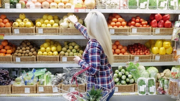 Girl Buys Fruit and Vegetables in Shop