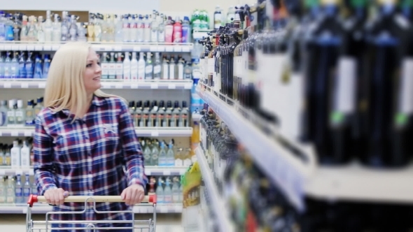 Woman Chooses Wine in a Supermarket