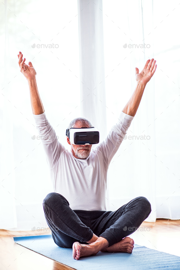 Senior man with VR goggles doing exercise at home. - Stock Photo - Images