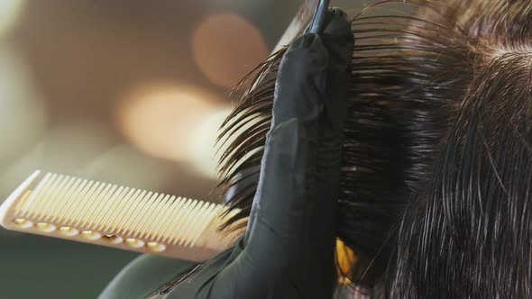 Barber in Gloves Cutting Client's Wet Hair with a Thinning Scissors alt