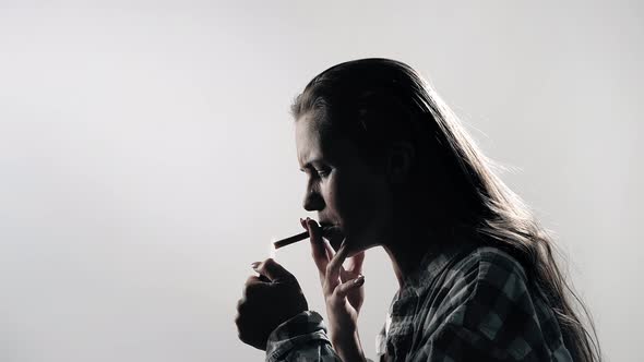 Woman Smoking. Silhouette of an Upset Woman