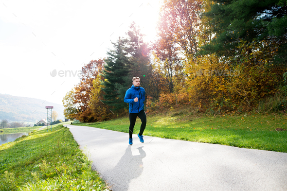 Young athlete running in park in colorful autumn nature. - Stock Photo - Images