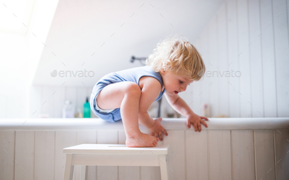 Toddler boy in a dangerous situation in the bathroom. - Stock Photo - Images