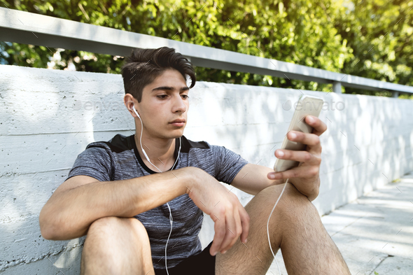 Runner with smartphone in the city, listening to music. - Stock Photo - Images