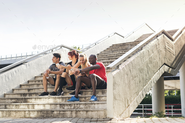 Young runners in the city sitting on the stairs. - Stock Photo - Images