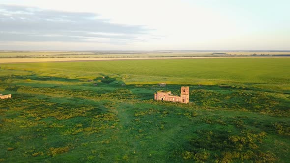 Abandoned Red Brick Church and Green Field
