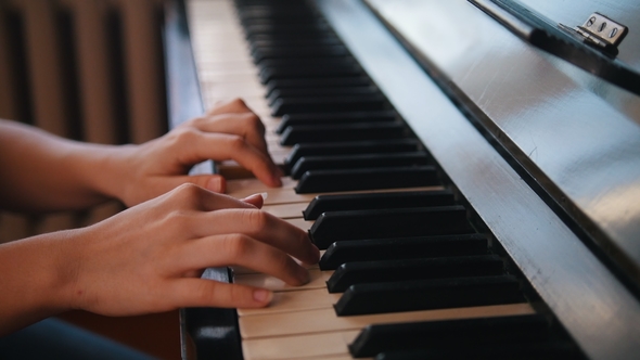 Hands of Young Teen Girl Playing on the Piano alt