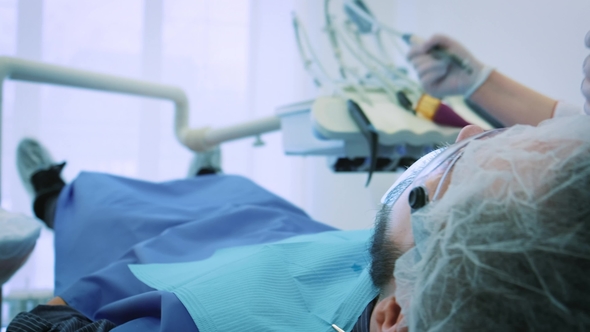Dentist at Work in the Office A Female Doctor Examines the Teeth and Jaws of a Male Patient alt