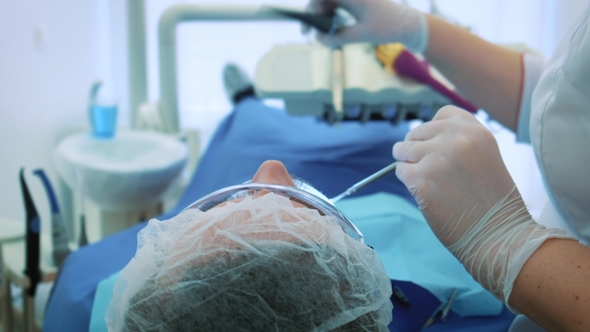 Dentist at Work in the Office A Female Doctor Examines the Teeth and Jaws of a Male Patient alt